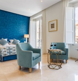 Bedroom with two lounge chairs and the blue wallpaper