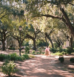 Two women walking on the square with live oaks