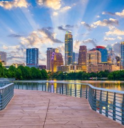 city skyline with lake and boardwalk in foreground