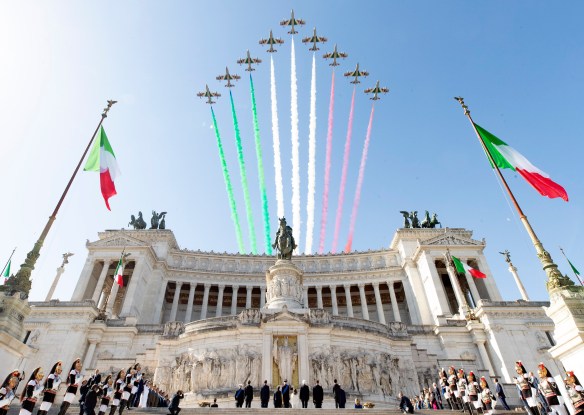 Planes are flying above the historic building leaving the three-colored trail