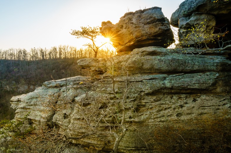 Setting sun shining from behind the rocks at the Pinnacles hiking area in Berea