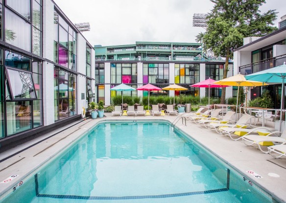 hotel pool with loungers and colorful umbrellas