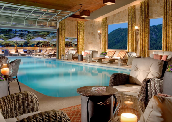 indoor swimming pool with garage door that opens up to outdoor patio