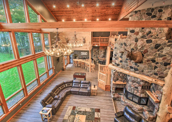 spacious living area with stone fireplace and floor-to-ceiling windows